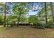 Large backyard with a deck, stairs, and a lush lawn surrounded by mature trees at 2608 Knightwood Rd, Fuquay Varina, NC 27526