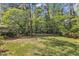 Large backyard with mature trees and lawn. A playground is nestled amongst the trees at 2608 Knightwood Rd, Fuquay Varina, NC 27526