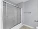 Bathroom shower with sliding doors and chrome fixtures inside a light blue bathroom with towel bars at 2608 Knightwood Rd, Fuquay Varina, NC 27526