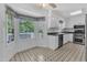 Open eat-in kitchen is bright with plenty of natural light and white cabinetry at 2608 Knightwood Rd, Fuquay Varina, NC 27526