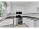 Bright kitchen features white cabinetry, stainless steel appliances, and a double oven range at 2608 Knightwood Rd, Fuquay Varina, NC 27526