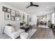 Bright living room featuring hardwood floors, a comfortable sofa, and an open floor plan leading to the dining area at 270 Wendover Pkwy, Pittsboro, NC 27312