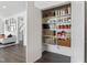 Organized walk-in pantry with white shelving, woven baskets and a variety of food items at 270 Wendover Pkwy, Pittsboro, NC 27312