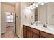 Bright bathroom with double sinks, wood cabinets, and doorway to a bedroom at 2737 Casper Creek Ln, Raleigh, NC 27616