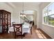 An open dining room with hardwood floors, elegant furniture, a decorative cabinet, and an arched entrance to the living room at 2737 Casper Creek Ln, Raleigh, NC 27616