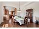 An open dining room with hardwood floors, elegant furniture, a decorative cabinet, and an arched entrance to the kitchen at 2737 Casper Creek Ln, Raleigh, NC 27616