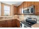 Classic kitchen with stainless steel range and microwave, and hardwood cabinets and backsplash at 2737 Casper Creek Ln, Raleigh, NC 27616