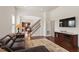 Spacious living room with wood floors, dark leather sofa, and television at 2737 Casper Creek Ln, Raleigh, NC 27616