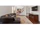 Inviting living room featuring dark leather sofa, wood flooring, and open floor plan at 2737 Casper Creek Ln, Raleigh, NC 27616