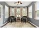 Comfortable sunroom with wicker chairs, neutral rug and lots of light from large windows with decorative curtains at 2737 Casper Creek Ln, Raleigh, NC 27616