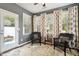 Comfortable sunroom with wicker chairs, neutral rug and lots of light from large windows with decorative curtains at 2737 Casper Creek Ln, Raleigh, NC 27616