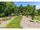 Picturesque backyard featuring a gazebo, mulch and grass pathways, framed by lush greenery and mature trees at 3005 Buckhorn Rd, Sanford, NC 27330
