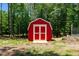 Close up view of barn, painted red and white with trees surrounding, on sunny day at 3005 Buckhorn Rd, Sanford, NC 27330