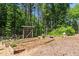 Backyard featuring custom wooden gate, raised garden beds, and trees at 3005 Buckhorn Rd, Sanford, NC 27330