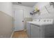 Functional laundry room with modern washer and dryer units, storage shelving, and tiled flooring at 3005 Buckhorn Rd, Sanford, NC 27330