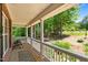 Inviting front porch with comfortable chairs, a stylish rug, and a view of the lush backyard and gazebo at 3005 Buckhorn Rd, Sanford, NC 27330