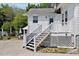 Home's back exterior with stairs, a table and chairs, and mature trees at 310 Henderson St, Oxford, NC 27565