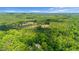 Expansive aerial shot of a wooded area with a house and pool visible, showcasing the property's natural surroundings at 318 Hepowil Trce, Hillsborough, NC 27278