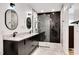 Modern bathroom with herringbone tile shower, marble floors, and a black double vanity at 318 Hepowil Trce, Hillsborough, NC 27278