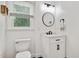 Stylish powder bathroom with white vanity, round mirror, modern lighting, and toilet at 318 Hepowil Trce, Hillsborough, NC 27278