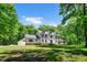 Charming two-story home with landscaped yard surrounded by lush greenery and a long driveway at 318 Hepowil Trce, Hillsborough, NC 27278