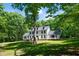 Stately two-story home surrounded by mature trees and a lush lawn, offering a sense of privacy at 318 Hepowil Trce, Hillsborough, NC 27278