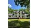 Attractive white home exterior with black trim, a well-manicured lawn, and mature trees in the background at 318 Hepowil Trce, Hillsborough, NC 27278