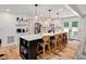 A modern kitchen with a large island, white cabinets, pendant lighting, and stainless steel appliances at 318 Hepowil Trce, Hillsborough, NC 27278