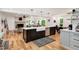 An open kitchen with a large island, a farmhouse sink, pendant lighting, and hardwood floors at 318 Hepowil Trce, Hillsborough, NC 27278
