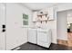 Modern laundry room with newer front load washer and dryer, floating shelves, and hexagon tile floors at 318 Hepowil Trce, Hillsborough, NC 27278