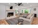 Living room featuring fireplace, hardwood floors, large windows providing lots of natural light, and comfortable sofas at 318 Hepowil Trce, Hillsborough, NC 27278
