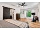 Inviting bedroom with natural light, hardwood floors, ceiling fan, and a sliding barn door to bathroom at 318 Hepowil Trce, Hillsborough, NC 27278