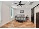 Serene bedroom with hardwood floors, large window, ceiling fan and sliding barn door to bathroom at 318 Hepowil Trce, Hillsborough, NC 27278