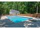 Sparkling in-ground pool with a diving board, surrounded by a brick privacy fence and mature trees at 318 Hepowil Trce, Hillsborough, NC 27278