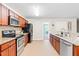 Kitchen featuring stainless appliances, wood cabinets, granite counters, and an open doorway at 33 Carrington Cir, Angier, NC 27501