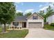 Charming, beige two-story home with a well-manicured lawn and a spacious two-car garage at 334 Huckleberry Loop, Mebane, NC 27302