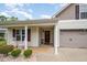 Inviting front door with rocking chairs, decorative shrubbery, and convenient attached two-car garage at 334 Huckleberry Loop, Mebane, NC 27302