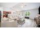 Bright living room with a large sectional sofa, hardwood floors, and a view of the backyard at 334 Huckleberry Loop, Mebane, NC 27302