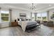 Spacious main bedroom with a tray ceiling, a chandelier, and large windows allowing for lots of natural light at 3415 Great Smoky Pl, Lillington, NC 27546