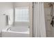 Relaxing bathroom features separate shower and tub with a large bright window at 3810 Stoneybrook Dr, Durham, NC 27705