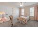 Bedroom with a single bed, desk, carpet, a ceiling fan and two windows with blinds and curtains at 3810 Stoneybrook Dr, Durham, NC 27705