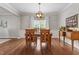 Warm dining room showcasing wood floors, a round table, and natural light from the window at 3810 Stoneybrook Dr, Durham, NC 27705