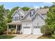 Beautiful home with a covered front porch, attached two-car garage, well-maintained lawn and lush green trees at 3810 Stoneybrook Dr, Durham, NC 27705