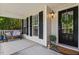 Cozy covered front porch features a bench, decor, and a welcoming front door with stylish wreath at 3810 Stoneybrook Dr, Durham, NC 27705