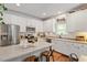 Well-lit kitchen with white cabinets, stainless steel appliances, and a breakfast bar for seating at 3810 Stoneybrook Dr, Durham, NC 27705