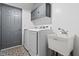 Convenient laundry room with utility sink, storage cabinets, and patterned tile floors at 3810 Stoneybrook Dr, Durham, NC 27705