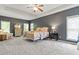 Spacious main bedroom boasts a tray ceiling, soft carpet, and bright windows at 3810 Stoneybrook Dr, Durham, NC 27705