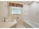 Clean white bathroom featuring a tub, shower, white subway tile, and a window offering natural light at 400 Bowling Creek Rd, Chapel Hill, NC 27514