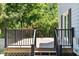 Rear wooden deck with black railing, offers views of the surrounding greenery, enhancing outdoor living space at 400 Bowling Creek Rd, Chapel Hill, NC 27514