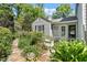 Exterior of guest house with light gray siding, complemented by lush landscaping and flower beds at 400 Bowling Creek Rd, Chapel Hill, NC 27514